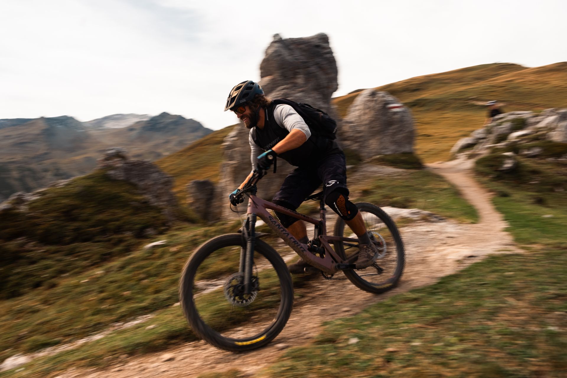 Smiling rider descending past a rock formation