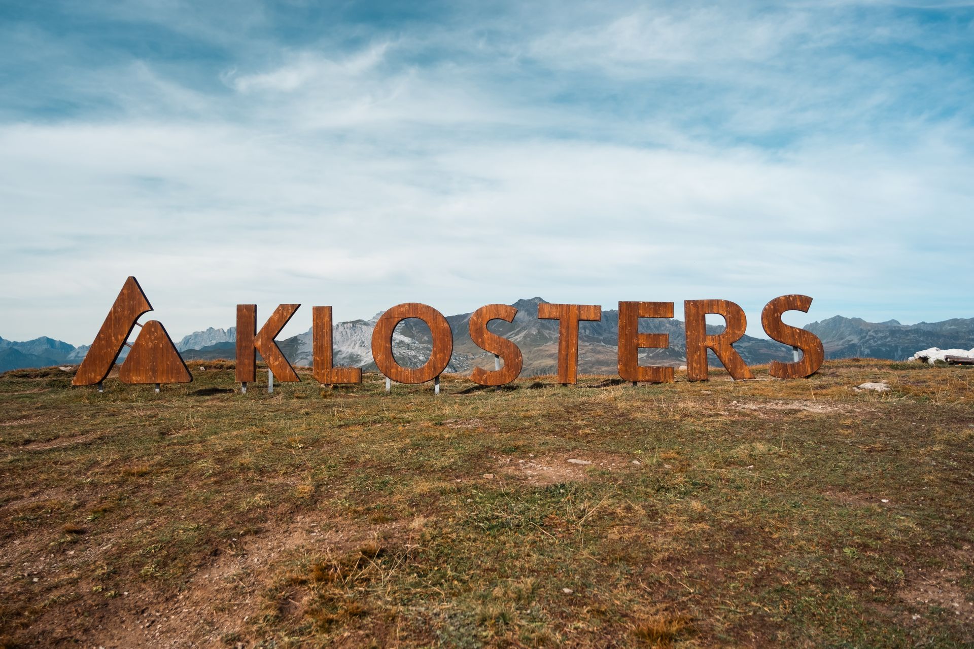 Wooden KLOSTERS trailhead sign on a mountain ridge