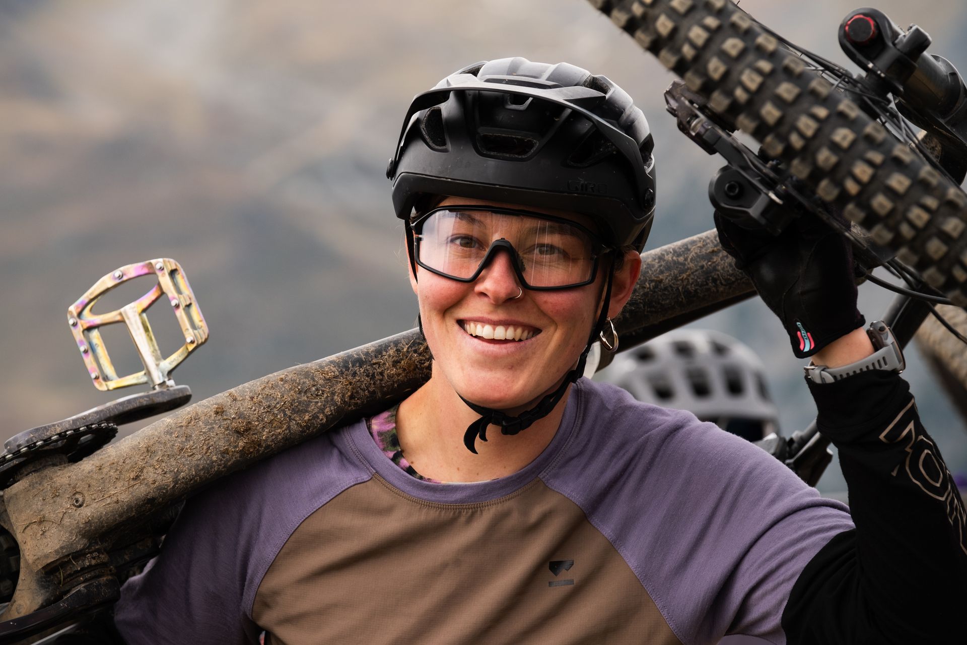 Annika, co-founder and guide, smiling while carrying her bike
